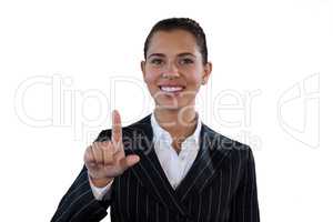 Portrait of smiling businesswoman in suit touching invisible interface