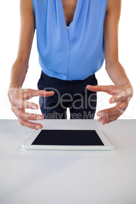 Mid section of businesswoman gesturing over tablet computer while planning