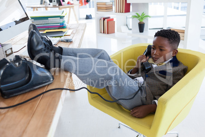 Full length of businessman talking on landline phone