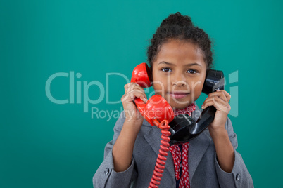 Portrait of businesswoman talking land line phones