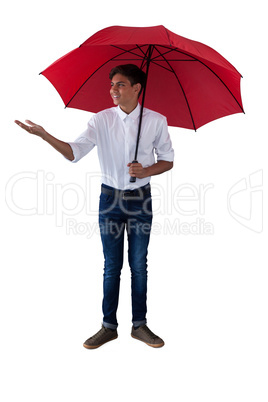 Boy standing under a red umbrella