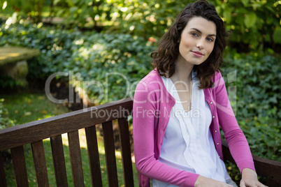 Portrait of woman sitting on park bench