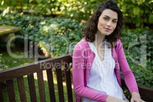 Portrait of woman sitting on park bench