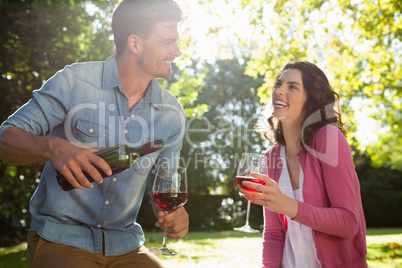 Couple having glass of wine in park