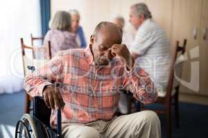 Depressed disabled senior man sitting on wheelchair