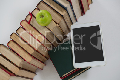 Apple, digital tablet and books on white background