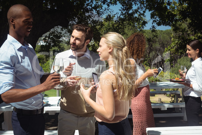 Friends interacting while having glass of wine in restaurant