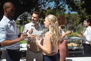 Friends interacting while having glass of wine in restaurant