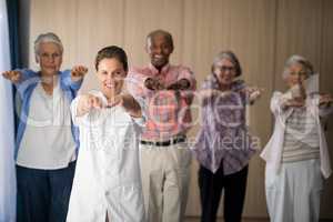Portrait of smiling female doctor and seniors exercising