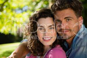 Smiling couple sitting together in park