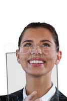 Close up of smiling businesswoman looking up while using glass interface