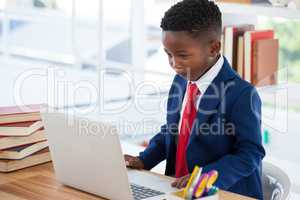 Businessman making face while using laptop