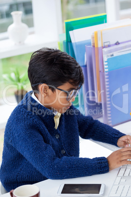 Side view of businessman using desktop computer at desk