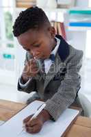 High angle view of businessman writing on paper at clipboard