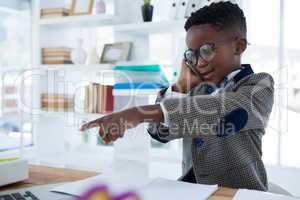 Businessman talking on phone and pointing at desk