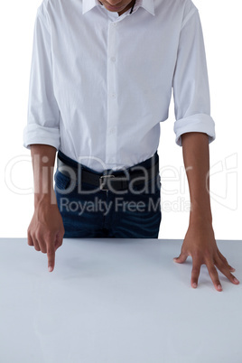 Teenage boy touching invisible screen on table