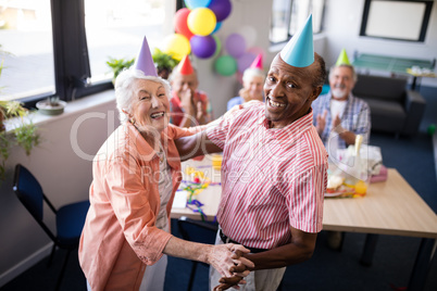 Portrait of happy senior couple dancing at party