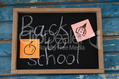 Close-up of slate with text and sticky notes