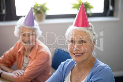 Portrait of smiling senior friends wearing party hats