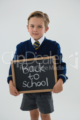 Schoolboy holding slate with text against white background