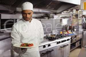 Chef holding delicious dish in kitchen