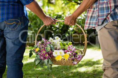 Senior couple walking in garden with flower basket