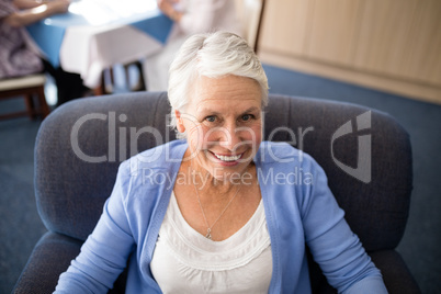 High angle view of smiling senior woman sitting on armchair