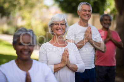 Portrait of senior people meditating in prayer position