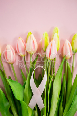 Overhead view of Breast Cancer Awareness ribbon on tulip flowers