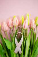 Overhead view of Breast Cancer Awareness ribbon on tulip flowers