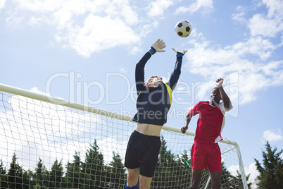 Male soccer players playing against sky