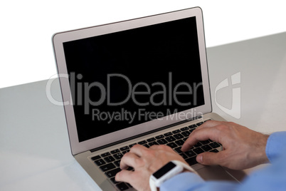 Cropped hands of businessman using laptop computer