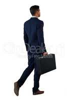 Rear view of businessman walking with briefcase