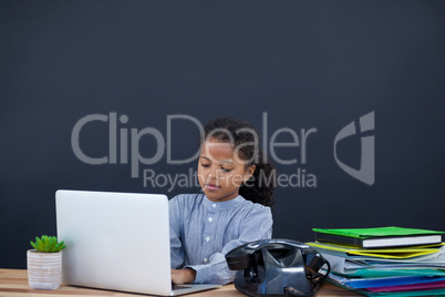 Businesswoman using laptop computer against black background