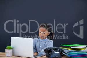 Businesswoman using laptop computer against black background