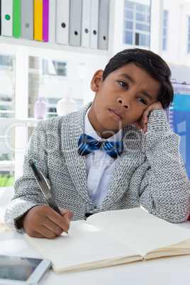 Bored businessman looking away while holding pen