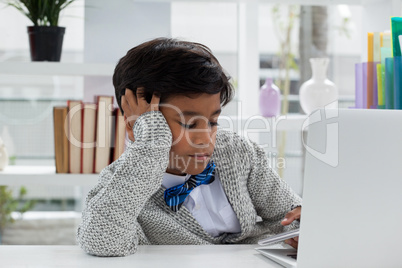 Bored businessman with hand in hair using mobile phone