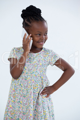 Smiling businesswoman with hand on hip talking on phone