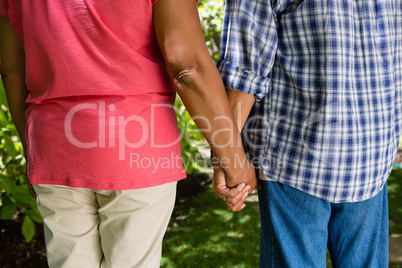 Mid-section of senior couple holding hands