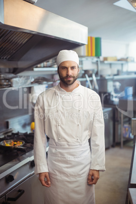 Portrait of smiling chef standing in commercial kitchen