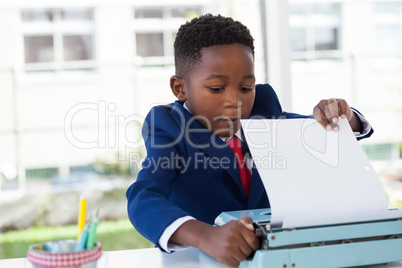 Businessman attaching paper in typewriter
