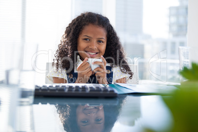 Portrait of smiling businesswoman holding coffee cup at desk