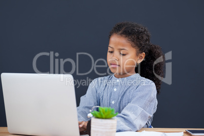 Confident businesswoman using laptop against black background
