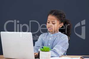 Confident businesswoman using laptop against black background