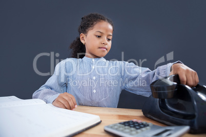 Businesswoman holding receiver of land line phone