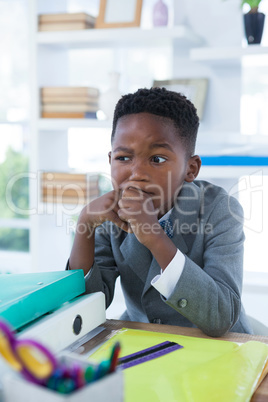 Thoughtful boy pretending as businessman