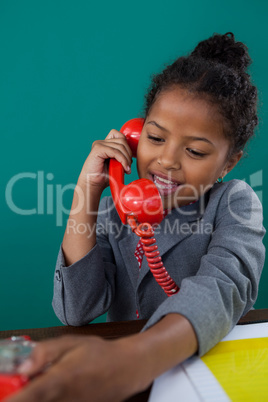 Happy businesswoman talking on land line phone