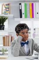 Bored businessman with hand on chin using laptop