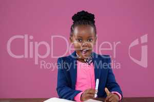 Portrait of surprised businesswoman writing report at desk