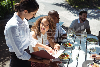 Waitress discussing the menu with woman in the restaurant